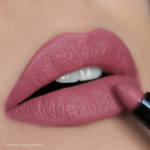 Close-up of a pink lipstick being applied to lips with a blurred background