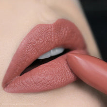 Close-up of a person wearing a textured pink lipstick.